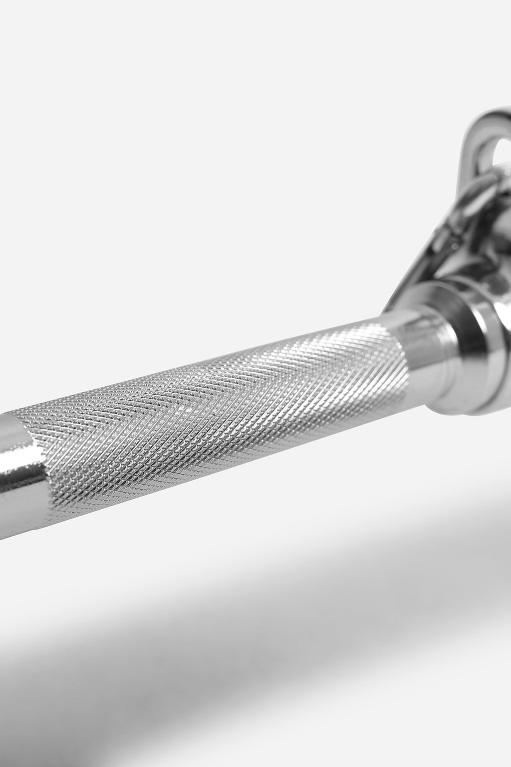 Close-up of knurled centre grip on chrome lat pulldown bar for secure cable machine workouts