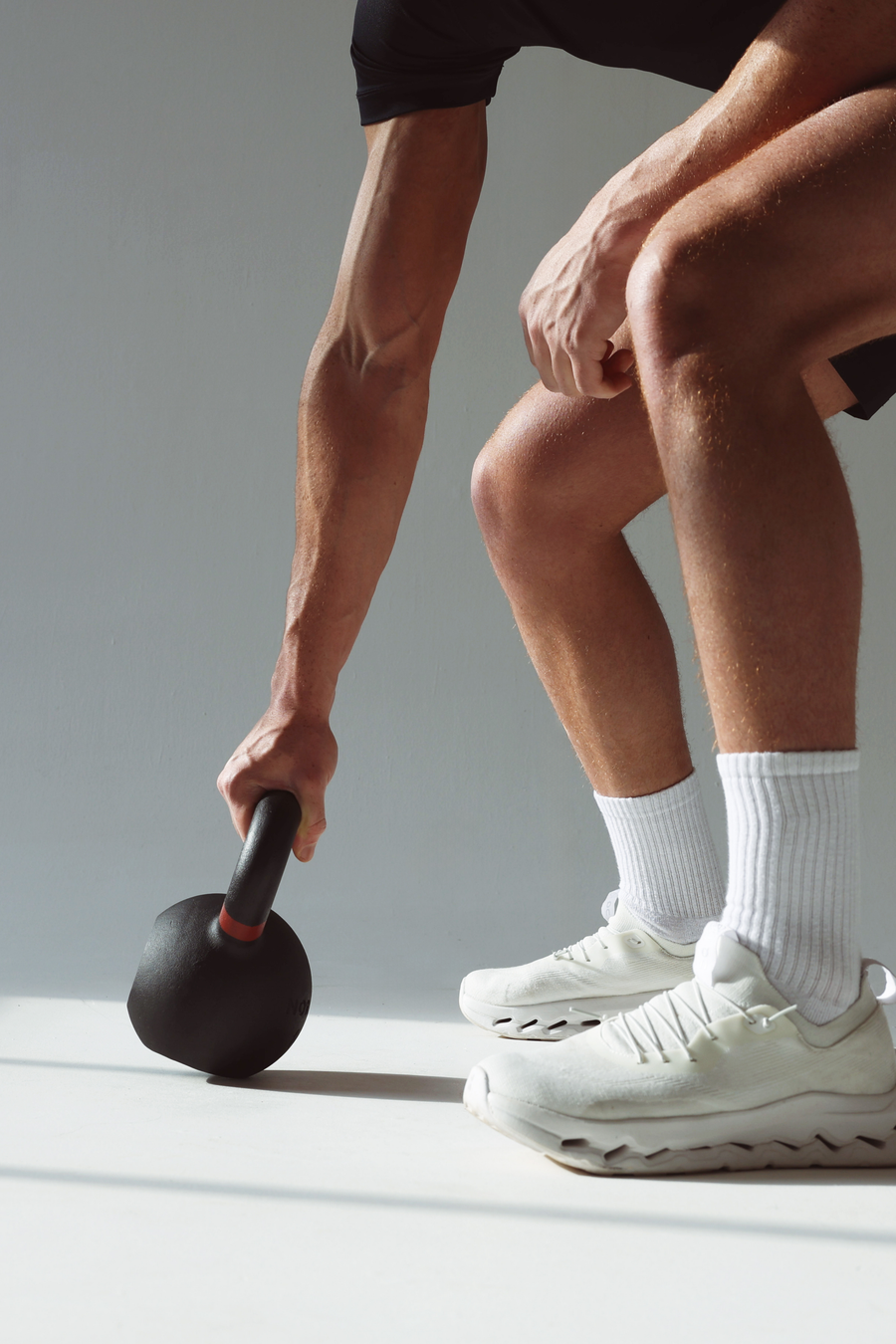 Firm gripping cast iron kettlebell during high intense workout 
