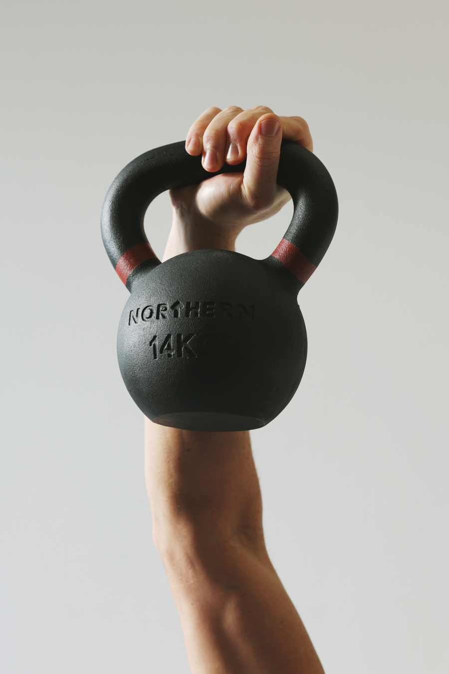 Overhead workout using cast iron kettlebell with red grip markings