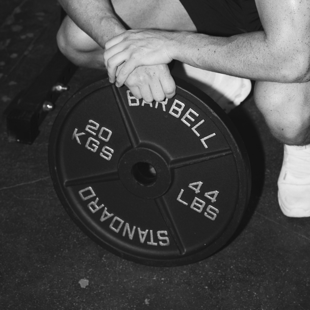 Athlete holding heavy duty cast iron weight plates