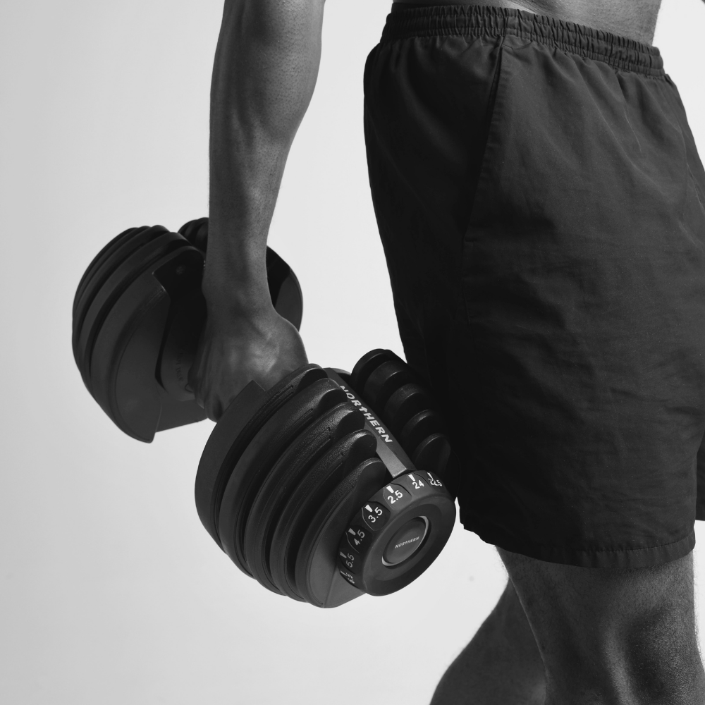 Man gripping Northern Adjustable Dumbbell to start with his dumbbell workout