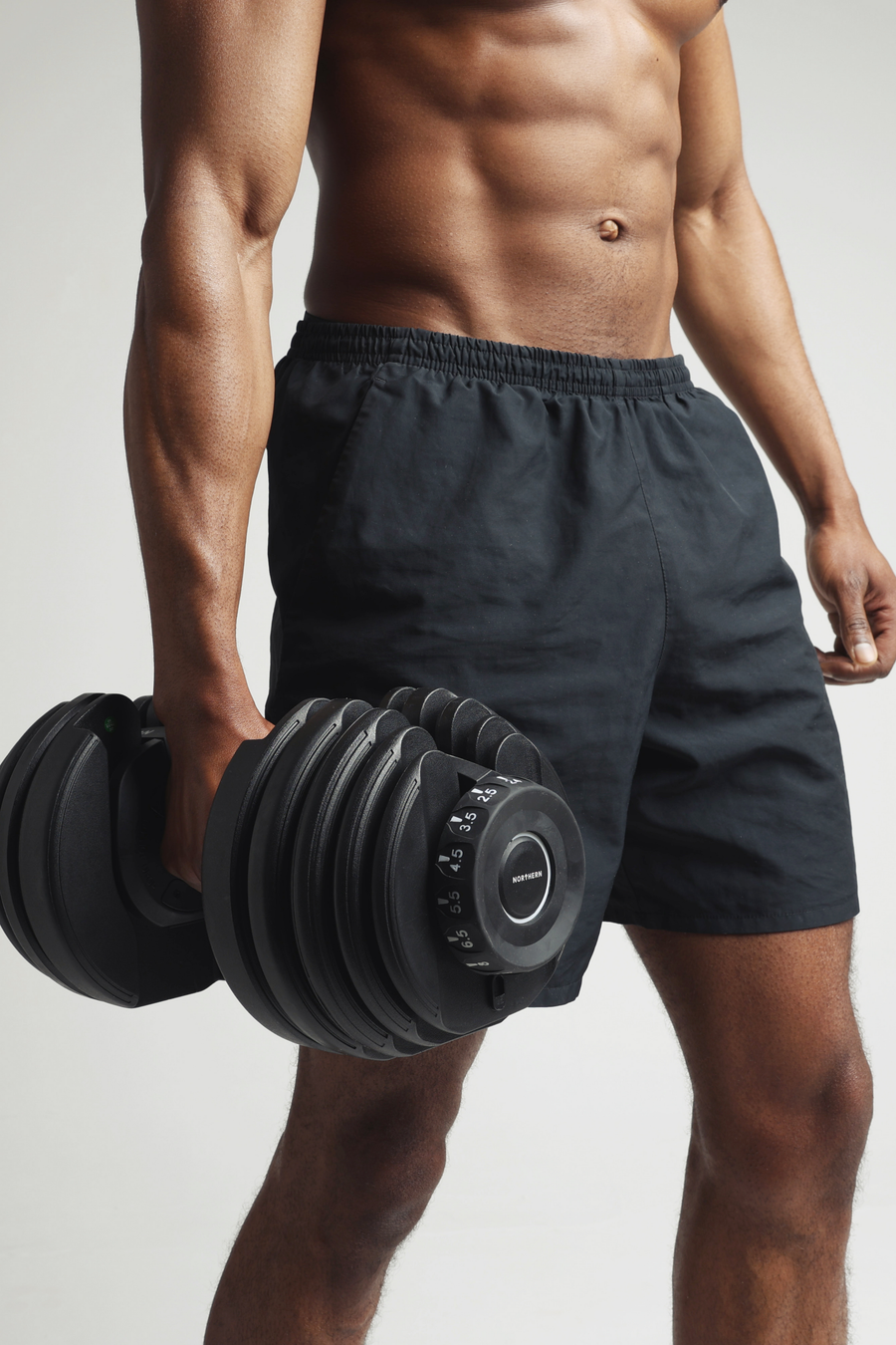 Man holding adjustable dumbbell after a dumbbell workout