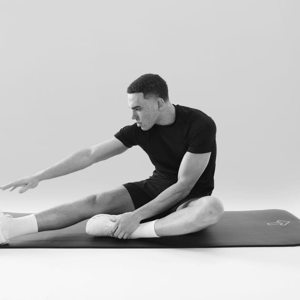 Man Stretching at Home Using Yoga Mats